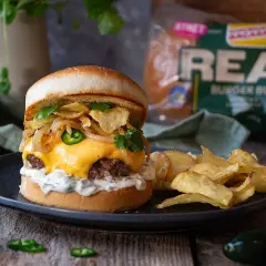 En saftig, hemmagjord hamburgare med smält ost, krispiga chips, jalapeños och lök. Serveras med pommes frites. En av de godaste hemmagjorda hamburgare du kan tänka dig!