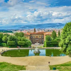 Vista panoramica dei Giardini di Boboli con stagno, palazzo e Firenze sullo sfondo.