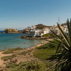 Costa de San José con casas blancas, playa y mar turquesa. Ideal para ver qué ver en San José y disfrutar del sol.