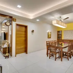 A modern dining room with a wooden table and chairs, featuring a sleek tile placement on the floor.
