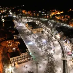 Krynica-Zdrój atrakcje wieczorem: ośnieżony deptak, iluminowane budynki i spacerujący ludzie tworzą magiczny zimowy krajobraz.