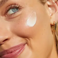 Viso di donna con crema all'acido salicilico come usarlo per una pelle luminosa.