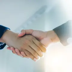 Uścisk dłoni symbolizujący zgodę i zatwierdzenie, jak przy udzielaniu absolutorium dla zarządu.