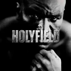 A close-up, black and white portrait of Evander Holyfield, the legendary boxer, with the word "HOLYFIELD" emblazoned across his face.