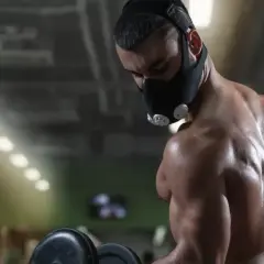 A muscular man trains with an oxygen restriction mask, exploring the oxygen restriction mask benefits for enhanced performance.