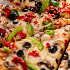 Pyszna pizza z serka wiejskiego, z pieczarkami, papryką i oliwkami. Idealna na szybki obiad.