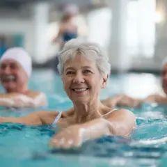 Des seniors souriants participent à un programme de mise en forme aquatique, profitant des bienfaits de l'eau pour leur bien-être.