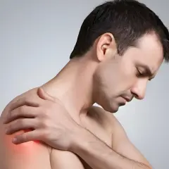 Mann mit schmerzender Schulter, die auf eine Frozen Shoulder hindeutet. Osteopathie kann hier Linderung verschaffen.