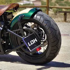 Detalle de moto customizada con asiento de cuero y guardabarros verde. La matrícula, con las medidas adecuadas, muestra el logo LDK.