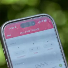 Ein Smartphone zeigt die "eezy eTarif Check-in" App. Ein Erwachsener und ein Kind sind für die Fahrt ausgewählt.