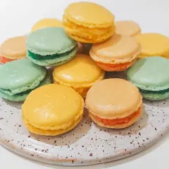 En hög med färgglada macarons i olika smaker, perfekta för ett macarons recept.