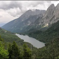 Paisaje montañoso con un lago sereno rodeado de bosques frondosos, ideal para explorar rutas desde Espot.