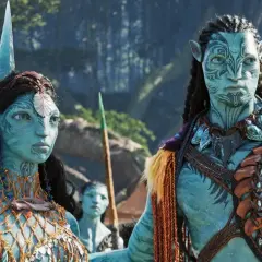 Neytiri i Jake w strojach Na'vi, czekają na premierę Avatar 3. Ich twarze zdobią plemienne wzory, a w tle widać fragmenty pandoriańskiego lasu.