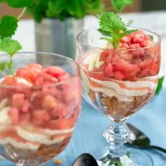 Två glas med en härlig dessert av rabarber i glas, varvad med krämig vanilj och smulad kaka. En frisk och somrig smakupplevelse.
