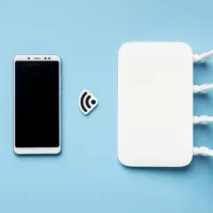 Smartfon i router Wi-Fi obok symbolu połączenia. Dowiedz się, jak udostępnić internet z telefonu.