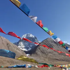 Kolorowe flagi modlitewne powiewają na tle majestatycznej góry Kailash, tworząc duchową atmosferę.