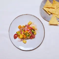 Kolorowe ceviche z owocami cytrusowymi, papryczką chili i cebulą, obok nachos.