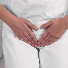 Mani che coprono l'area pelvica, suggerendo preoccupazione per ureaplasma parvum in gravidanza.
