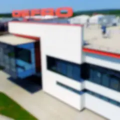 Nowoczesny budynek z czerwonym logo DE FRO. Profesjonalny serwis Defro Mazowieckie oferuje kompleksowe usługi.