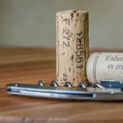 Korki do wina i korkociąg na drewnianym stole. Czas na wino bez korka!