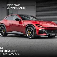 Czerwony Ferrari Purosangue, luksusowy SUV, prezentuje się dumnie przed budynkiem dealera.