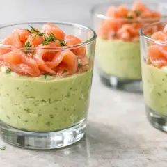 Verrine avocat saumon : une couche crémeuse d'avocat et d'herbes surmontée de fines tranches de saumon fumé, garnie d'aneth.