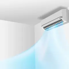 Klimatyzator ścienny emituje strumień chłodnego, niebieskiego powietrza w białym pomieszczeniu.