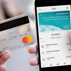 Karta N26 i smartfon z aplikacją bankową pokazującą saldo konta i ostatnie transakcje.