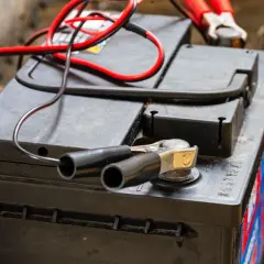 Pinces rouges et noires connectées à une batterie, prêt à savoir comment recharger les batteries d'un camping-car.