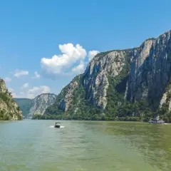 Rejs przez skalne wąwozy, gdzie rzeka tworzy naturalną, żelazną bramę. Dwie łodzie płyną po zielonej wodzie.
