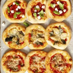 Mini pizze z mozzarellą, bazylią, pomidorami, karczochami i szpinakiem. Wiele opcji, co można dać na pizzę!