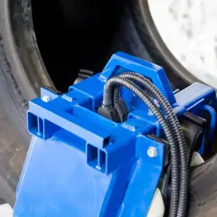 Herramienta azul para manipular el talon neumatico de un neumático grande.