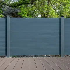 Nowoczesne wykończenie deski kompozytowej na tarasie i ogrodzeniu. Elegancka szara bariera chroni prywatność, a drewnopodobne deski tworzą przytulną przestrzeń.