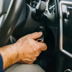 Mano insertando llave en el encendido. Al poner en marcha un motor de gasolina es conveniente tener el coche listo.