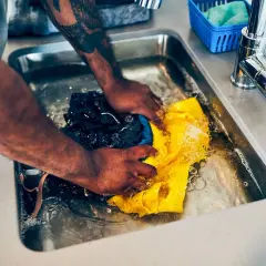 Hände waschen Kleidung im Spülbecken, eine Methode für waschen ohne waschmaschine.