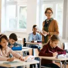 Lehrerin erklärt im Unterricht, während Schüler in Deutschland konzentriert arbeiten. Die Schulnoten sind ein wichtiger Teil des Bildungssystems.