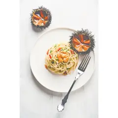 Spaghetti mit Seeigel-Soße und zwei ganze Seeigel. Entdecke, wie schmeckt Seeigel: eine delikate Meeresfrucht.
