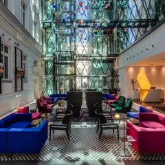 Nowoczesne wnętrze z kolorowymi sofami i szklaną fasadą, idealne na spotkanie w modnych restauracjach w Warszawie.