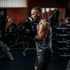 Mężczyzna w siłowni wykonuje ćwiczenie na biceps, napinając odruch z mięśnia dwugłowego.