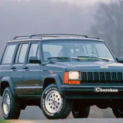 Klasyczny Jeep Cherokee ZJ z lat 90. na tle mglistego krajobrazu.