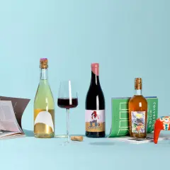 Butelki z winem, w tym zibibbo, kieliszek czerwonego wina, książki i czerwony koń Dala na jasnoniebieskim tle.