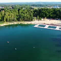 Letni dzień nad wodą w Trzebini. Ludzie odpoczywają na plaży i pływają w jeziorze, które przypomina Balaton.