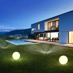 Modern villa con piscina iluminada y aspersores automáticos, un ejemplo de ideas domotica para un jardín perfecto.
