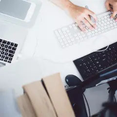 Ręce grafika komputerowego pracują nad klawiaturą, tworząc cyfrowe dzieła. Zastanawiasz się, ile zarabia grafik komputerowy?