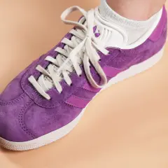 Une chaussure Adidas Gazelle violette, prête à nettoyer pour retrouver son éclat.