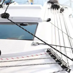 Dettaglio di un sartiame su una barca a vela, con un cavo per tendere le vele che passa attraverso una carrucola.
