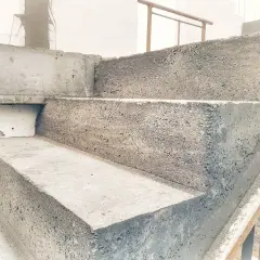 Schody betonowe w trakcie budowy. Widać surowy beton i formę, która jest szalunkiem.