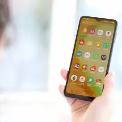 Dłoń trzyma smartfon z widocznymi ikonami aplikacji bankowych. Wśród nich jest mBank, co może być pomocne, gdy zastanawiasz się, jak zmienić numer telefonu w mBanku.