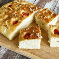 Oryginalna włoska focaccia przepis. Chrupiąca skórka, puszyste wnętrze, pomidorki i zioła. Idealna na przekąskę.