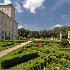 Jardins à la française de la Villa Borghese, avec des parterres de tulipes rouges et noires, des haies taillées et des statues.